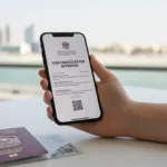A digital visa cancellation paper on a smartphone screen with a Dubai passport and Emirates ID on a desk.